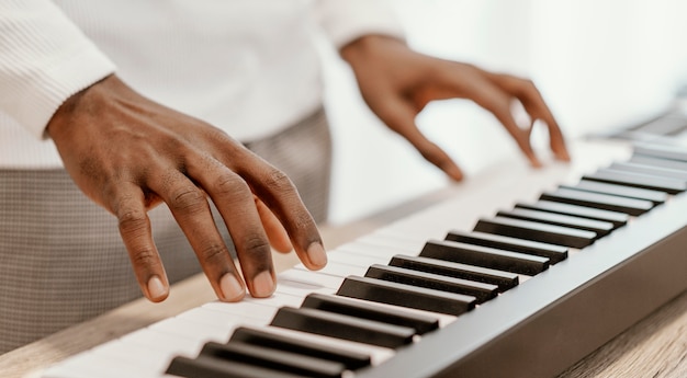 Männlicher Musiker, der elektrische Tastatur spielt