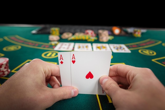 Männlicher Pokerspieler, der das von zwei Karten-Assen hält