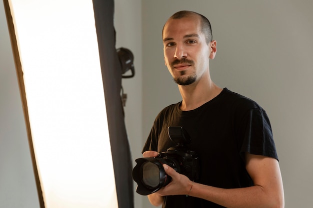 Kostenloses Foto männlicher produktfotograf, der seinen job im studio macht