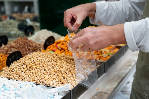 Kostenloses Foto männlicher produzent in seinem laden mit verschiedenen leckereien