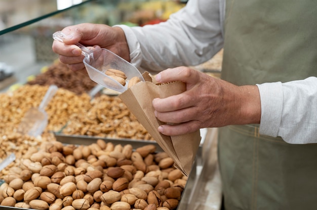 Männlicher Produzent in seinem Laden mit verschiedenen Leckereien