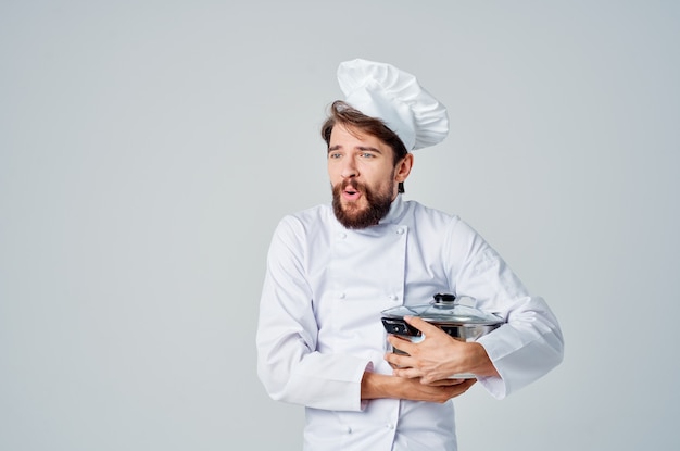 Männlicher professioneller koch mit einem topf in den händen, der ein lebensmittelrestaurant zubereitet? Premium Fotos