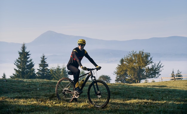 Männlicher Radfahrer, der Fahrrad in den Bergen fährt