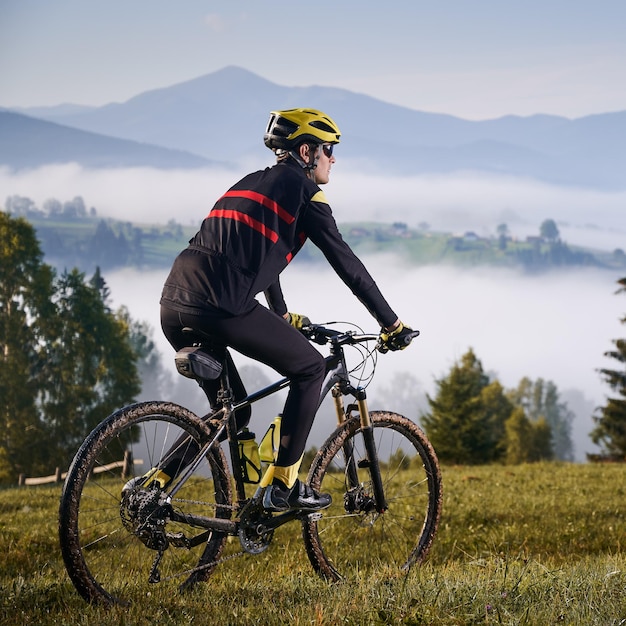 Männlicher Radfahrer, der Fahrrad in den Bergen fährt