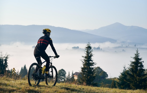 Männlicher Radfahrer, der Fahrrad in den Bergen fährt