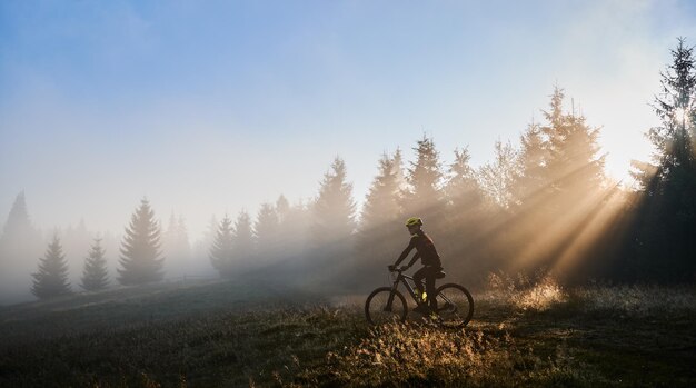 Männlicher Radfahrer, der morgens Fahrrad fährt