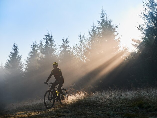 Männlicher Radfahrer, der morgens Fahrrad fährt