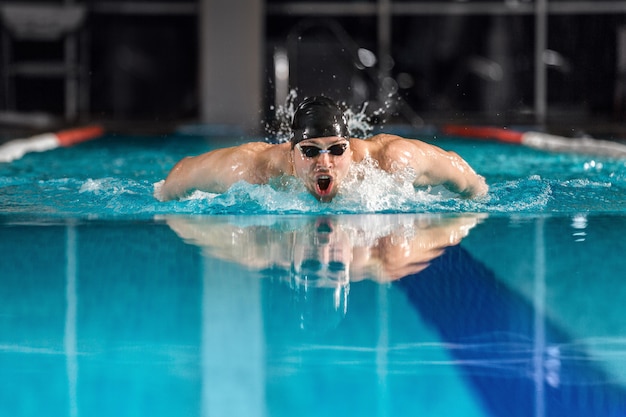 Männlicher Schwimmer, der den Schmetterlingsschlag schwimmt