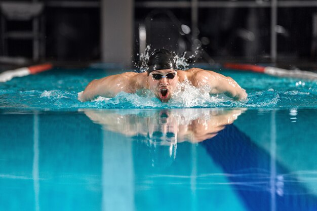 Männlicher Schwimmer, der den Schmetterlingsschlag schwimmt