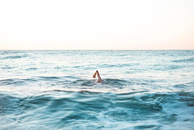 Männlicher Schwimmer, der im Ozean mit Kopienraum schwimmt