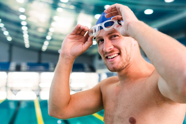 Männlicher Schwimmer der Nahaufnahme, der Schutzbrillen setzt