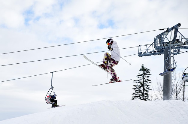 Männlicher Skifahrer, der im Skigebiet in die Luft springt