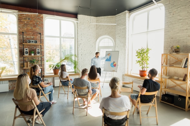 Männlicher Sprecher, der Präsentation im Saal des Universitätsworkshops gibt. Publikum oder Konferenzsaal