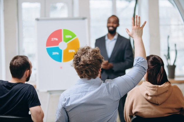 Kostenloses Foto männlicher sprecher, der präsentation im saal des universitätsworkshops gibt. publikum oder konferenzsaal