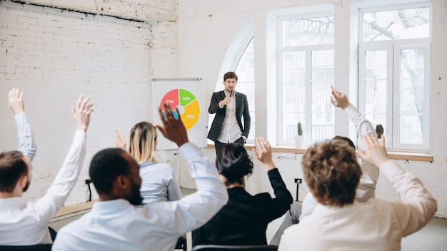 Männlicher Sprecher, der Präsentation im Saal des Universitätsworkshops gibt. Publikum oder Konferenzsaal