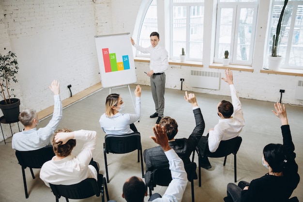 Männlicher Sprecher, der Präsentation im Saal des Universitätsworkshops gibt. Publikum oder Konferenzsaal