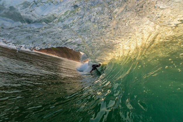 Männlicher Surfer, der Tricks macht, die die starken Wellen des Ozeans in Algarve, Portugal übernehmen