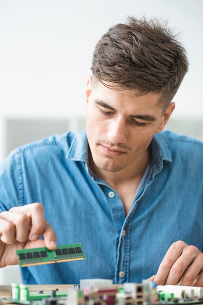 Kostenloses Foto männlicher techniker, der ram auf dem computermotherboard installiert