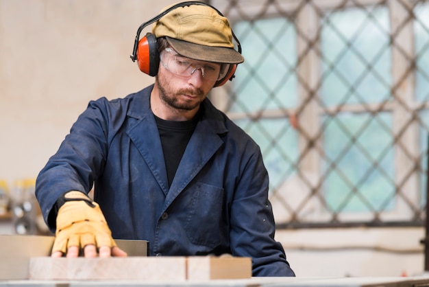 Kostenloses Foto männlicher tischler, der in der werkstatt arbeitet