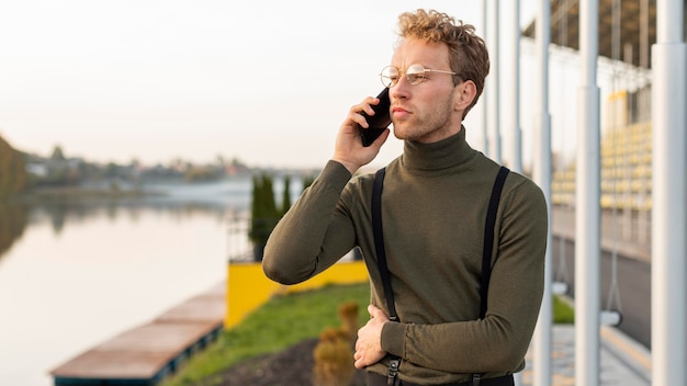 Männliches Modell, das wegschaut und am Telefon spricht