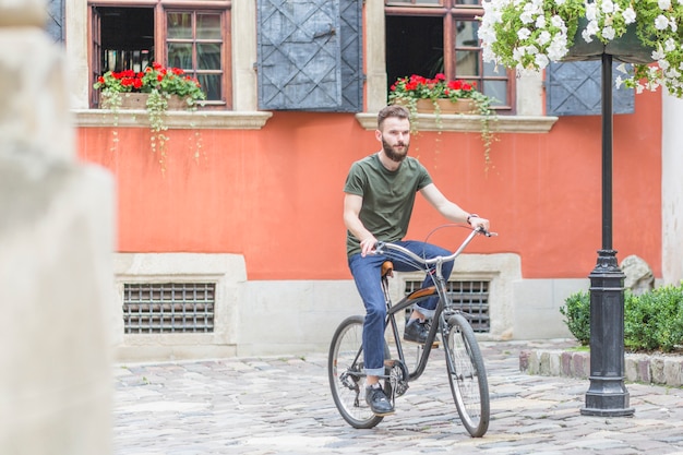 Männliches Radfahrerreitfahrrad vor Gebäude