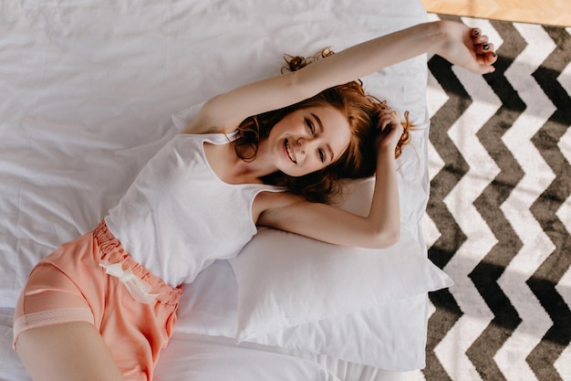 Magnificent müde Mädchen posiert im Bett mit sanftem Lächeln Overhead-Porträt von gutaussehenden Ingwer junge Frau