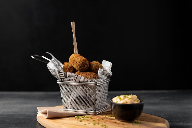 Mahlzeit mit Kroketten und Mayonnaise auf einem Holzteller