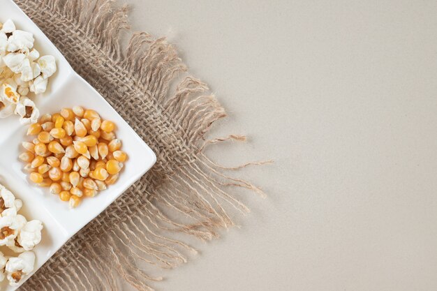 Maissamen mit Popcorns in einer weißen Platte.