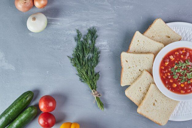 Maissuppe in tomatensauce mit zwiebeln und kräutern.