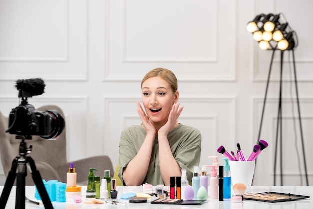 Kostenloses Foto make-up-bloggerin, die make-up-tutorial vor der kamera aufzeichnet, junges, süßes, hübsches mädchen, sehr fröhlich