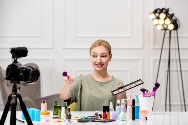 Make-up-Bloggerin, hübsches, süßes junges Mädchen, das Make-up-Tutorial auf Kamera mit Palette aufzeichnet