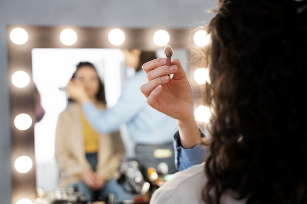 Make-up-Künstler bereitet das Model für das Fotoshooting vor