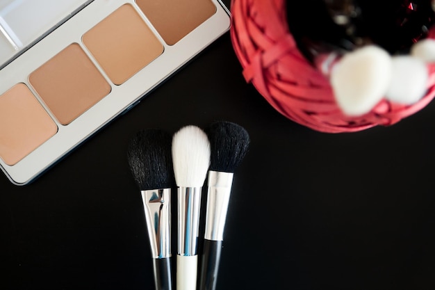 Make-up und Kosmetikprodukte auf schwarzem Hintergrund. Professionelle Kosmetik