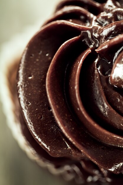 Makro von leckeren schönen appetitlichen Schokolade hausgemachten Cupcake auf Holzuntergrund.