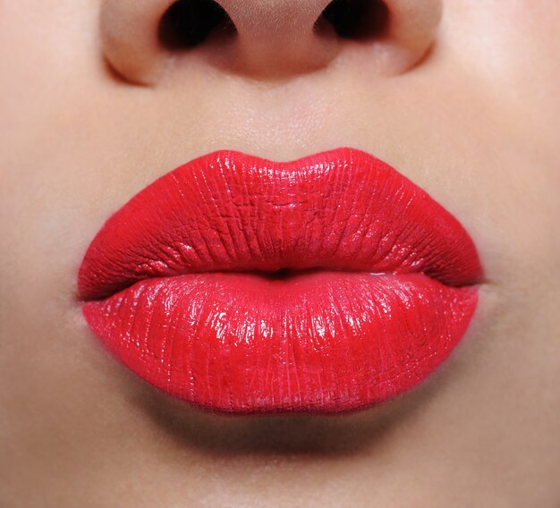 Makroaufnahme der schönen leuchtend roten weiblichen Lippen des Glamours Ð½Ð ° Ð´ÑƒÑ‚Ñ ‹Ð¹