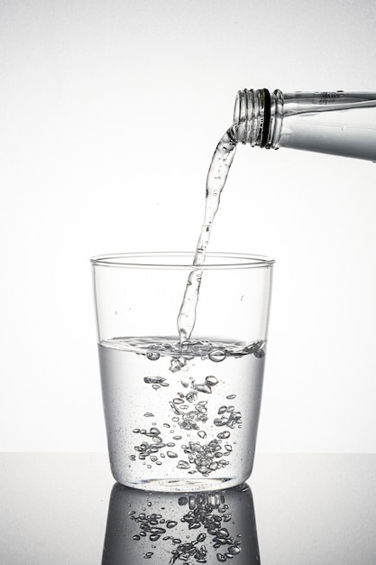 Makroaufnahme von Wasser, das in ein Glas gießt