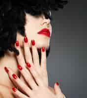 Kostenloses Foto makrofoto der frau mit mode roten nägeln und sinnlichen lippen
