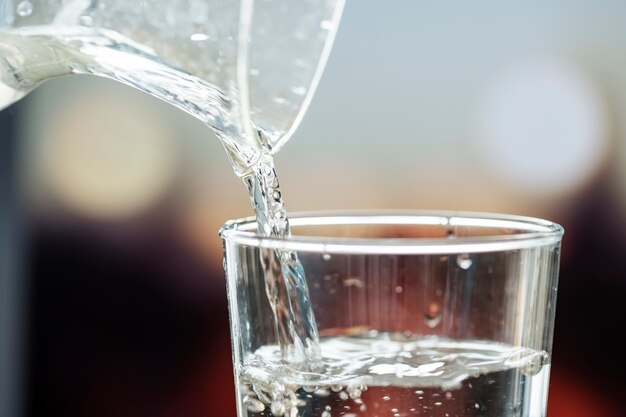 Makroschuß des strömenden Wassers in ein Glas