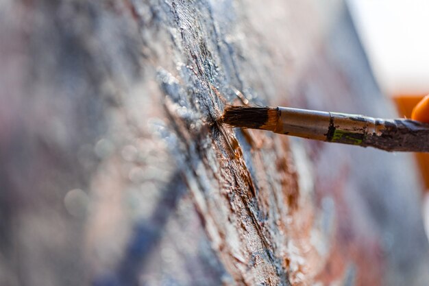 Malen mit einem alten Pinsel auf der Leinwand