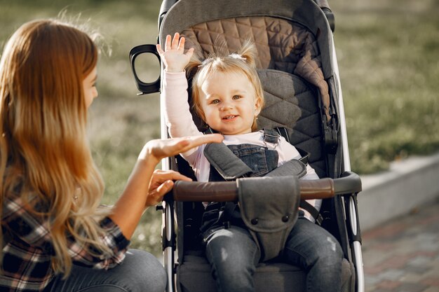 Mama auf der Stadtstraße. Frau mit ihrem Kleinkind sitzt in einem Kinderwagen. Familienkonzept.