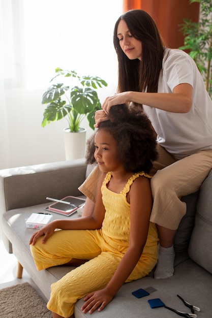 Mama hilft ihrem Kind beim Styling von Afro-Haaren