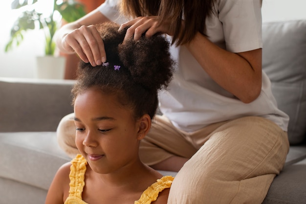 Mama hilft ihrem Kind beim Styling von Afro-Haaren