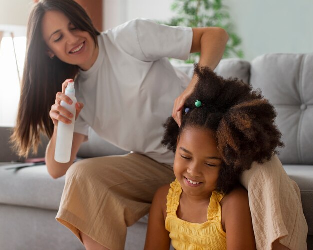 Mama hilft ihrem Kind beim Styling von Afro-Haaren