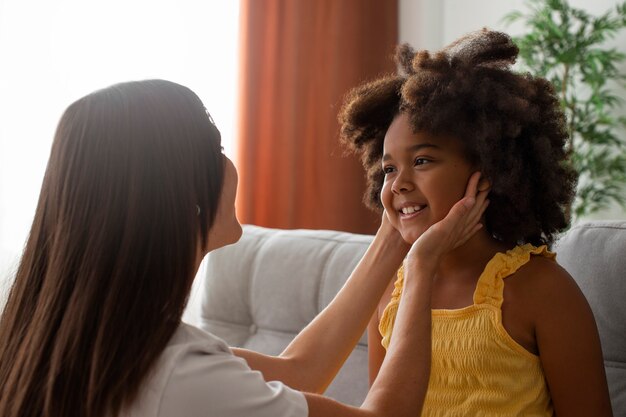 Mama hilft ihrem Kind beim Styling von Afro-Haaren