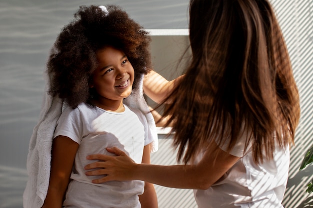 Mama hilft ihrem Kind beim Styling von Afro-Haaren