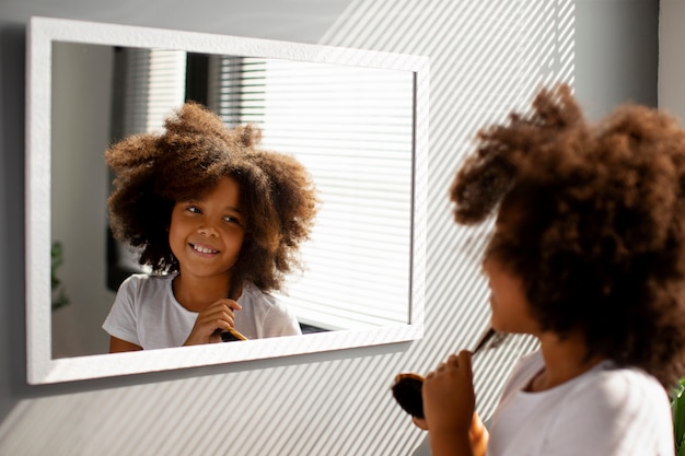 Mama hilft ihrem Kind beim Styling von Afro-Haaren