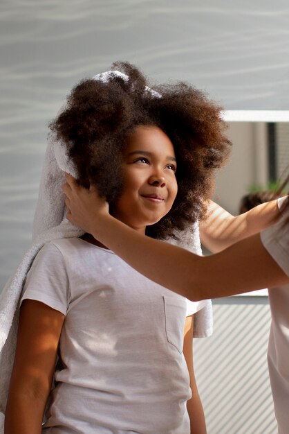 Mama hilft ihrem Kind beim Styling von Afro-Haaren