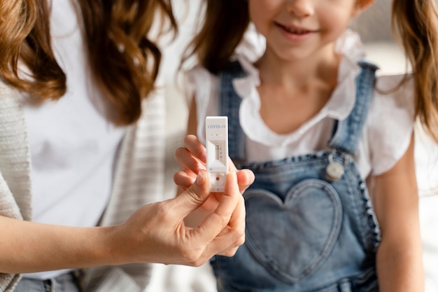 Mama macht mit ihrer Tochter einen Covid-Test zu Hause