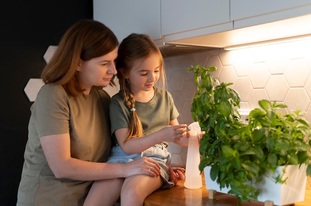 Mama zeigt ihrer Tochter, wie man eine Pflanze pflegt