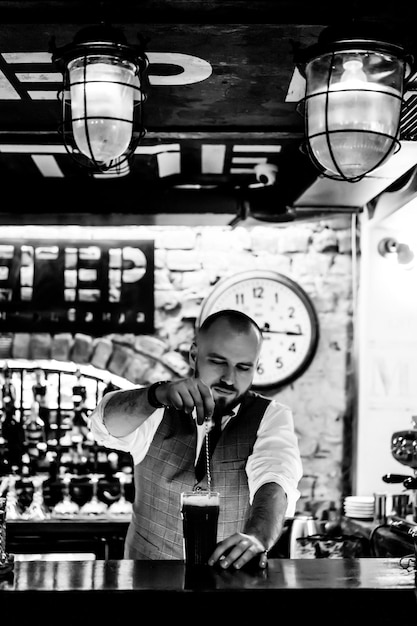 Man Barkeeper bei der Arbeit Der Barkeeper mixt Cocktails